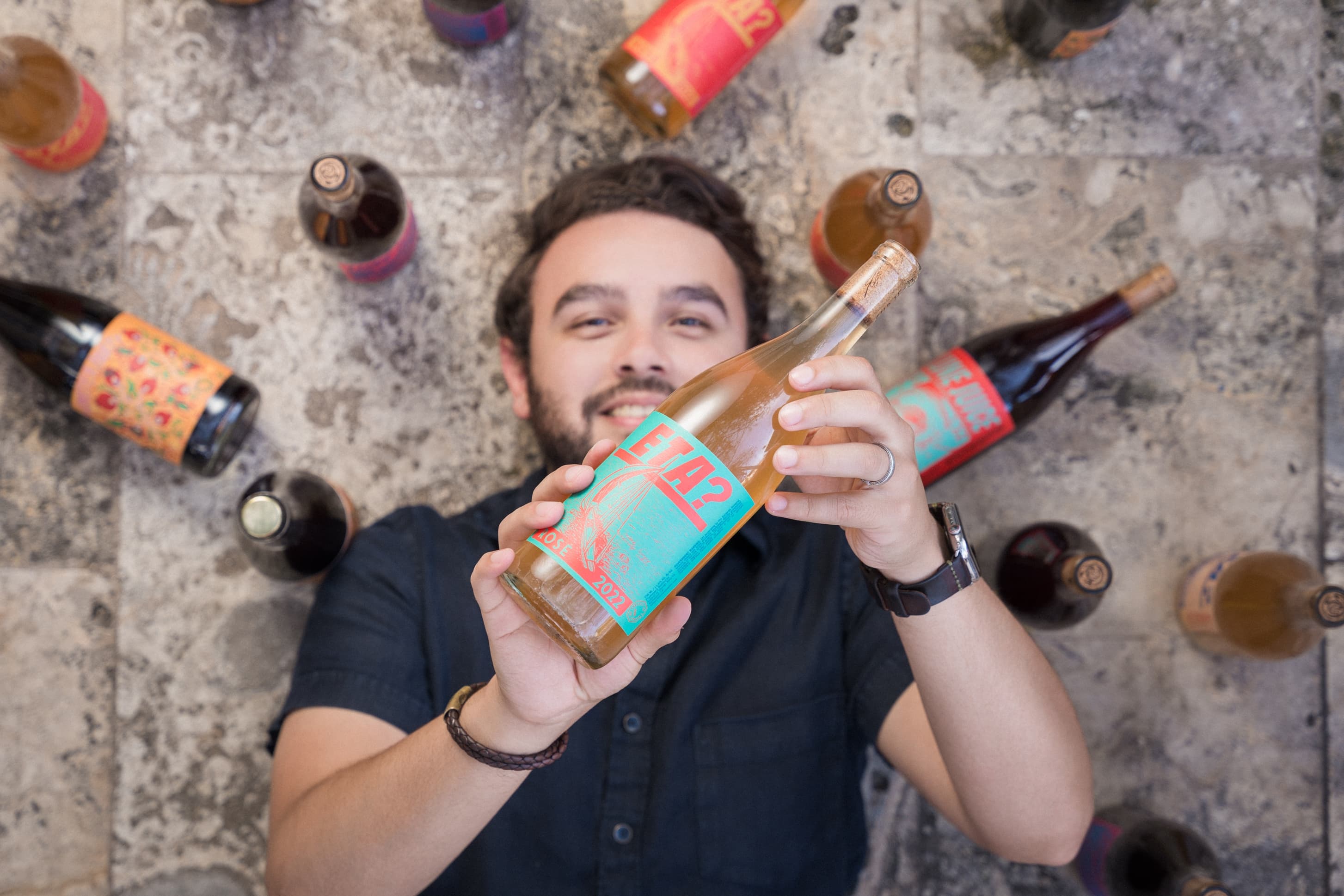 Rodrigo holding a bottle at Fog & Vine